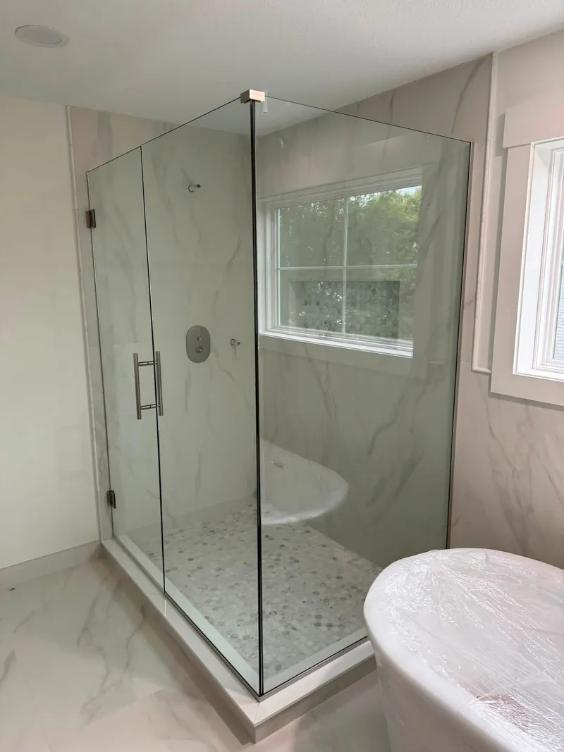 Corner glass shower enclosure with chrome hardware, installed by MN Glass