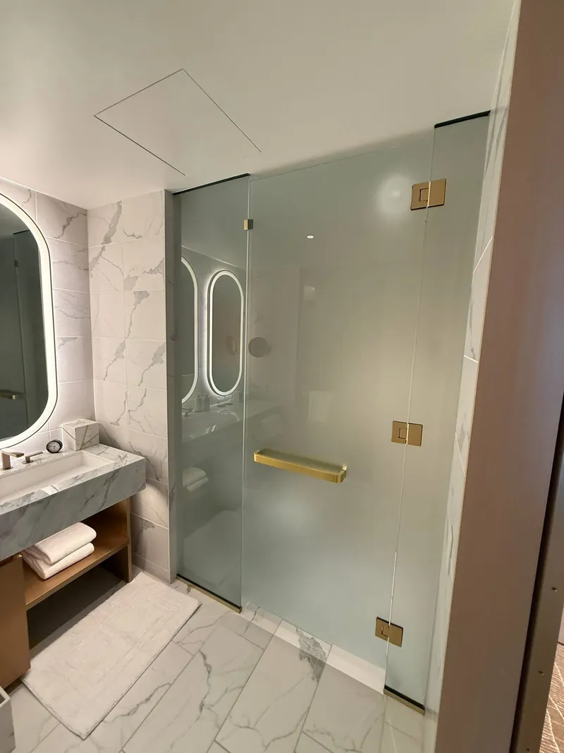 Frosted glass shower with gold hinges and handle