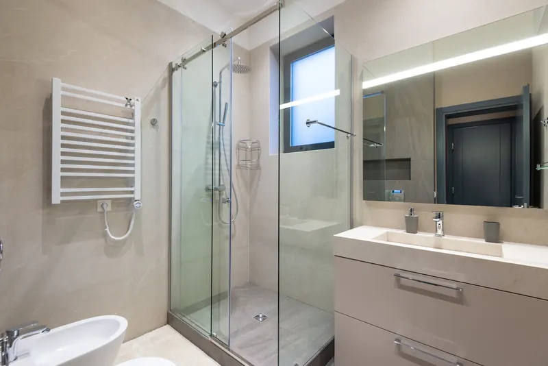 Sliding glass shower door on a rail