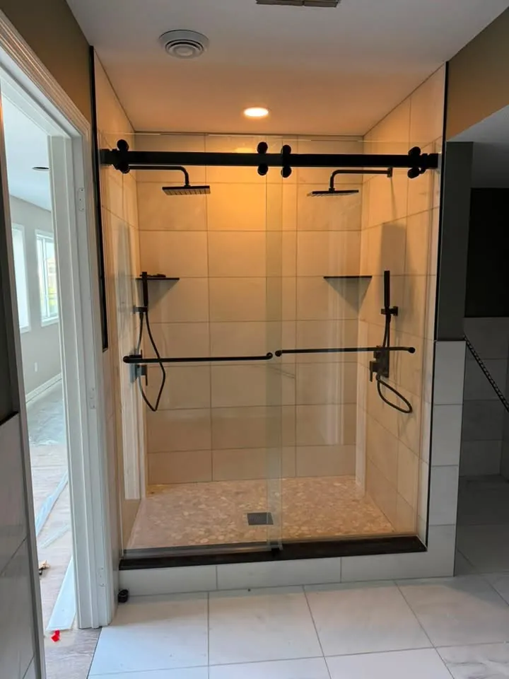 Sliding glass shower door on a matte black rail