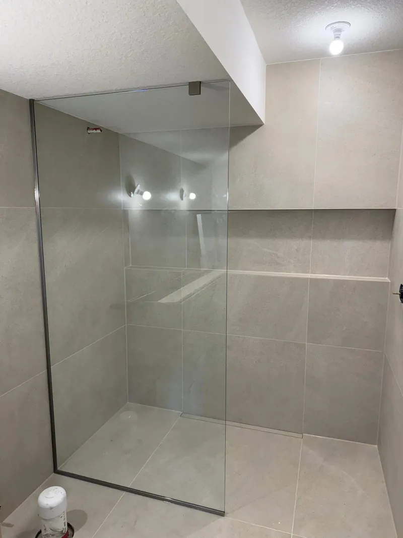 Walk-in shower with a single fixed glass panel