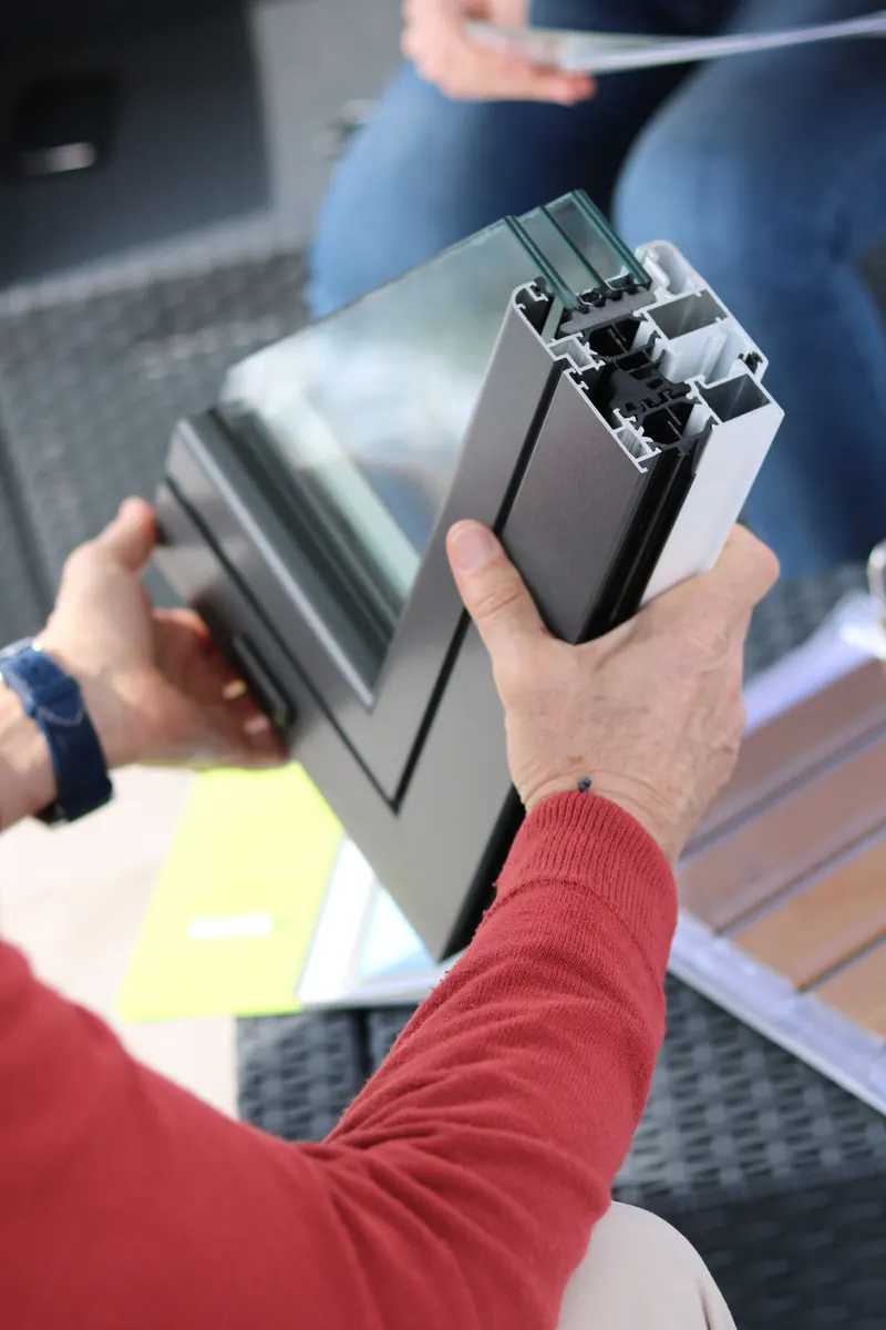 Hands holding a sample of a glass and frame profile